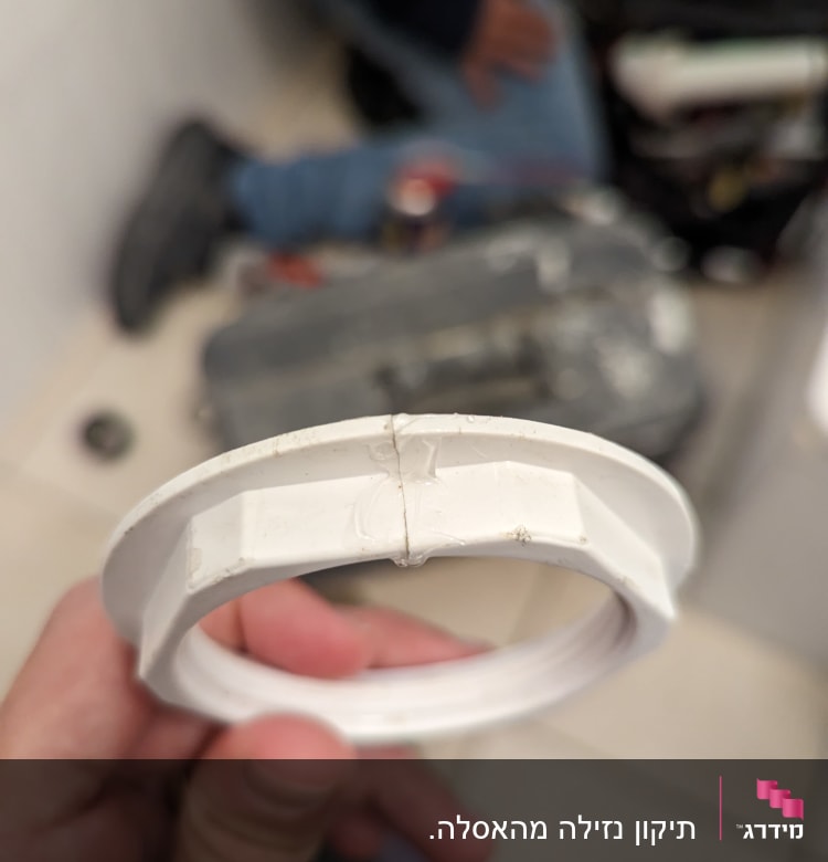 טבעת פלסטיק לבנה מוחזקת ביד של אינסטלטור